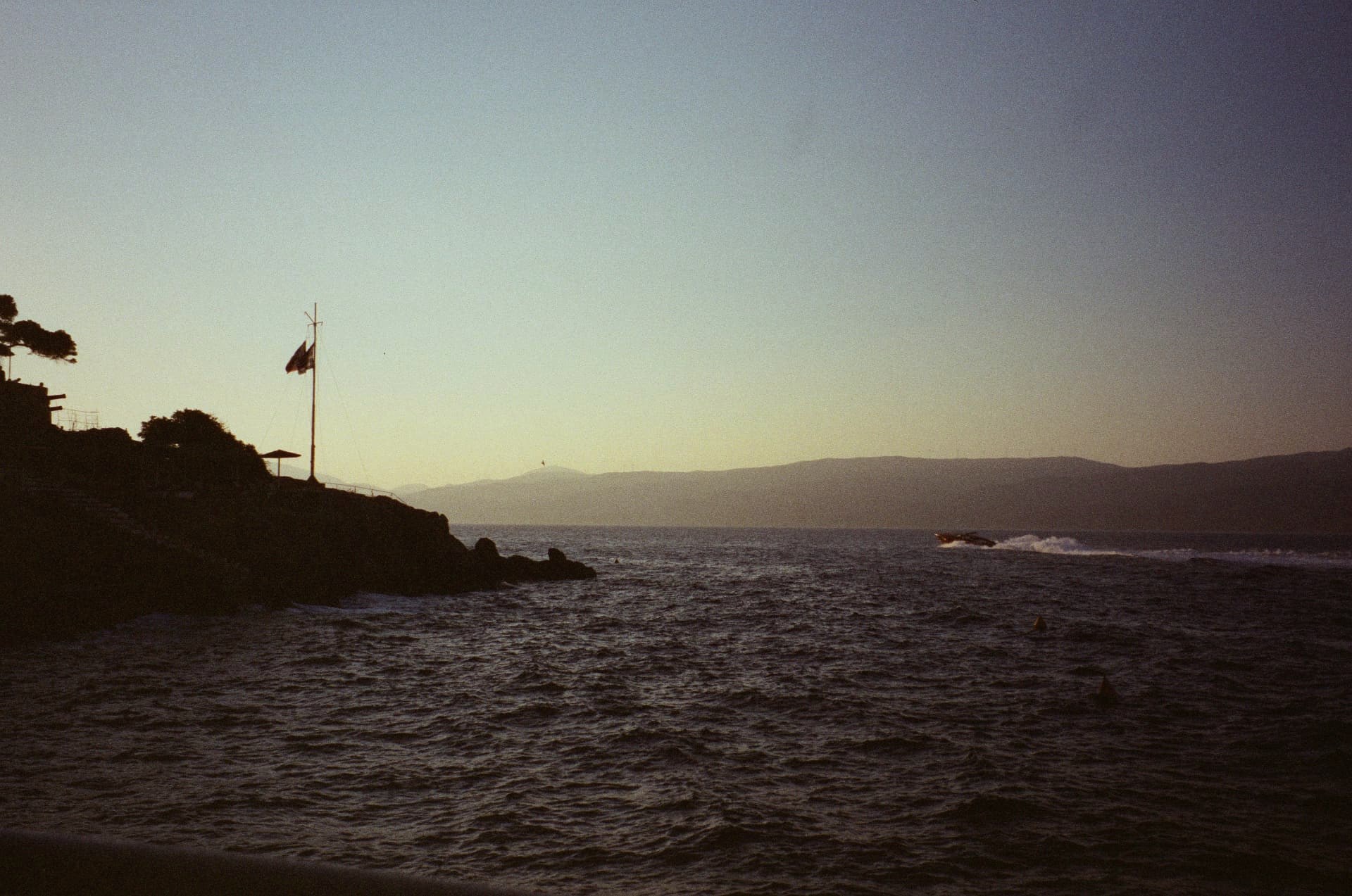 Dusk over the Hydra coastline, a boat heading home